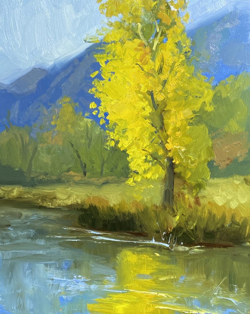 A photo of an original oil painting on panel of a landscape painting of gold trees in the blue mountains by Kelli Folsom.