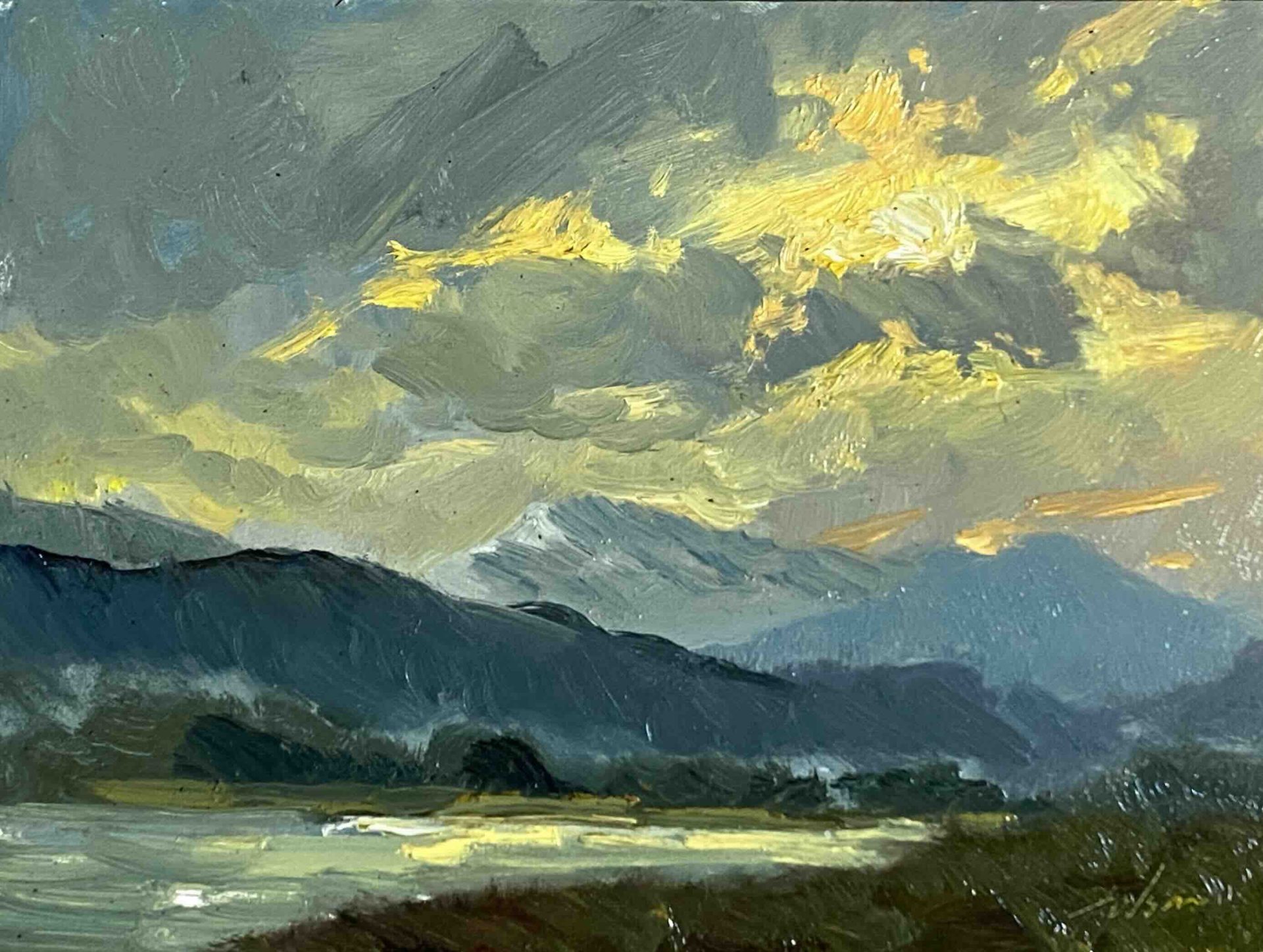 Experience the breathtaking beauty of a 8x6 inch landscape oil painting by Kelli Folsom, featuring a blue mountain range illuminated by sunlight breaking through the clouds. Painted in Folsom's distinctive loose style, this artwork captures the majestic essence of the mountains with expressive brushstrokes and dramatic lighting. The interplay of light and shadow adds depth and atmosphere, making this painting a stunning addition to any space, celebrating the awe-inspiring beauty of nature.