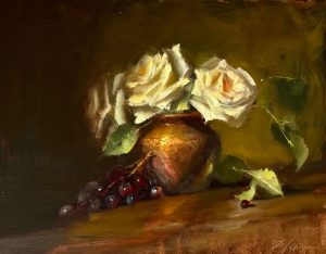 Still life oil painting featuring white roses arranged in a golden vessel with a cluster of deep red grapes resting on a warm wooden surface.