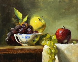 Original oil still life painting of red and green apples with green grapes and dark cherries in a blue-and-white ceramic bowl, arranged on a wooden table with soft, classical lighting.