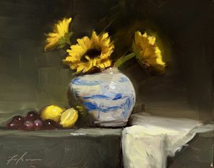 Original oil painting of bright yellow sunflowers in a blue and white porcelain vase with lemons, grapes, and white linen on a tabletop, painted in a traditional still life style.